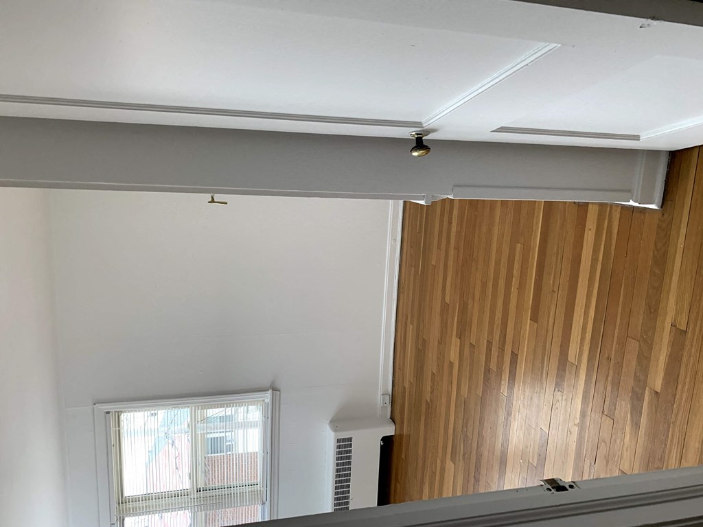 a room with white walls and a window and a light on the ceiling