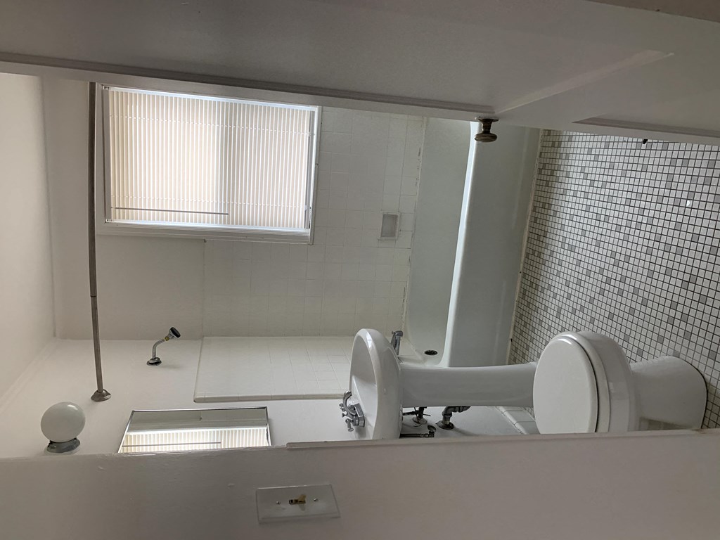 a bathroom with a toilet and a sink and a window