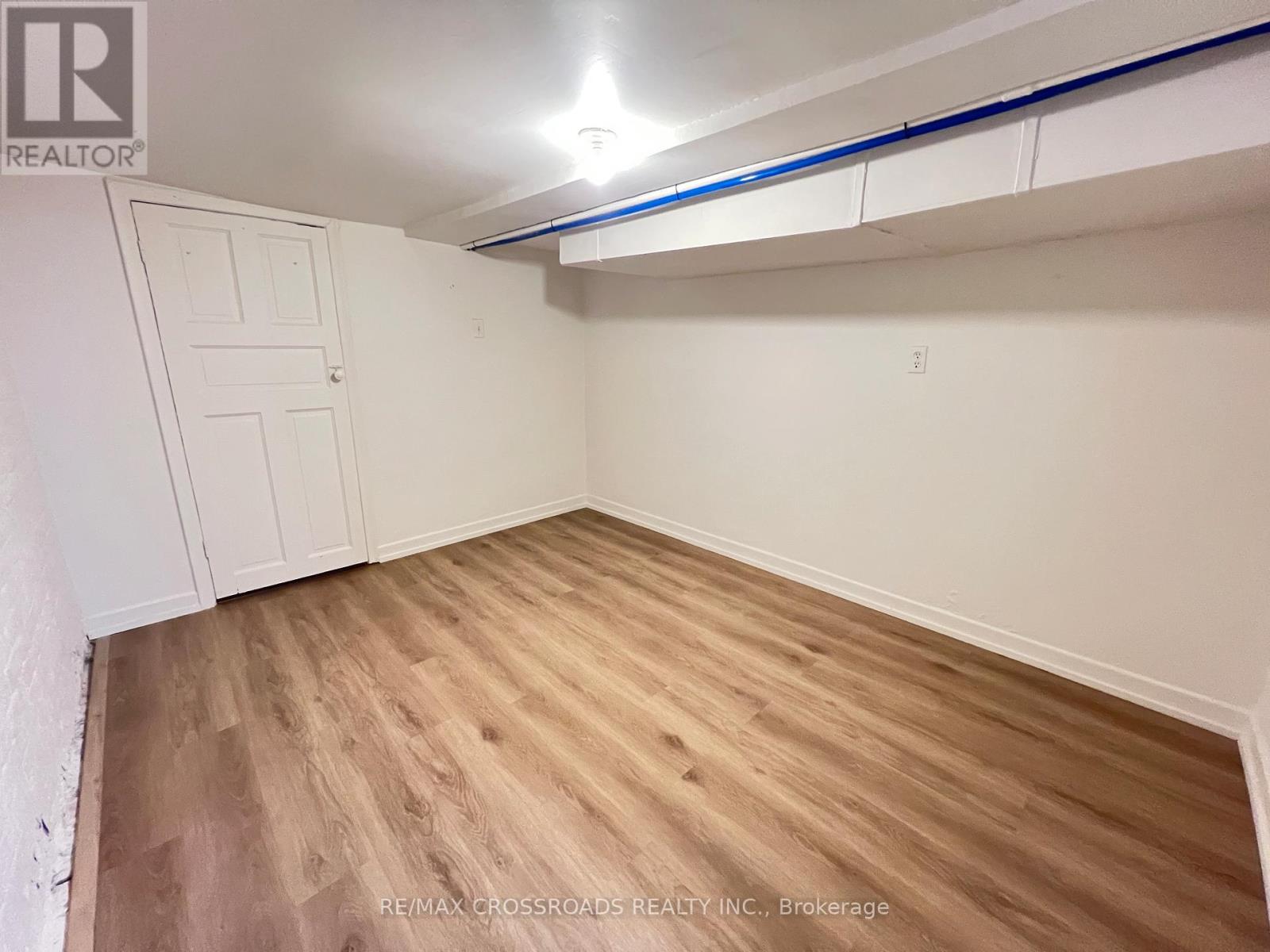 A room with wooden flooring and a white door.