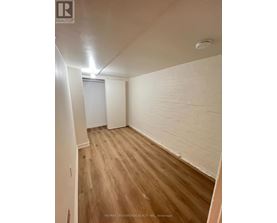 A room with wooden flooring and white walls.