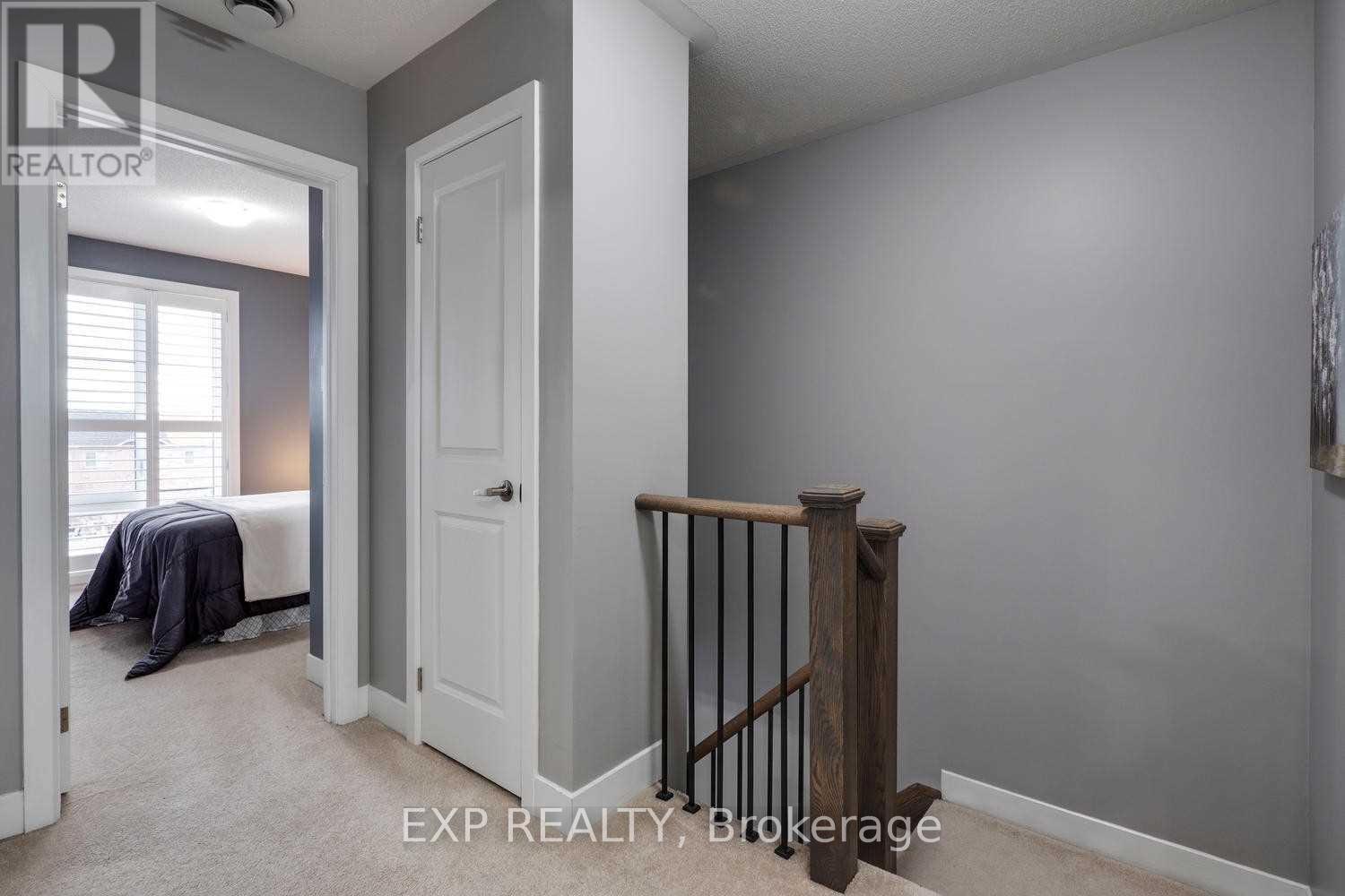 A bedroom with a bed, a window, and a wooden staircase.