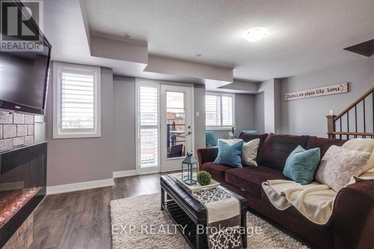 A living room with a brown couch and a flat screen TV.