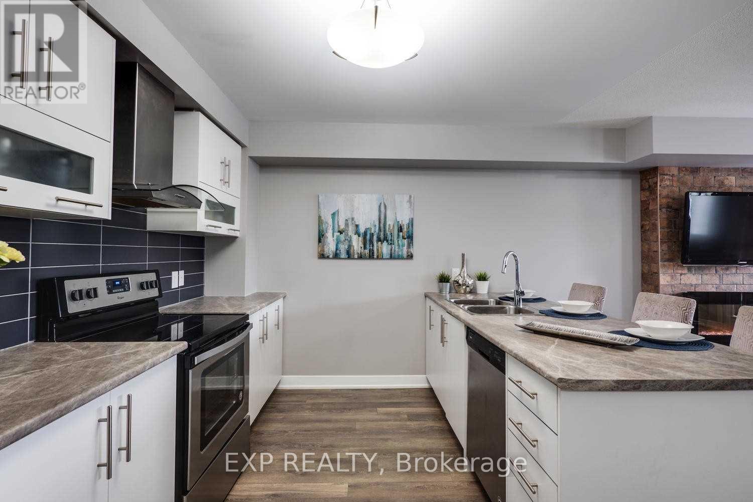 A kitchen with white cabinets and a grey countertop.