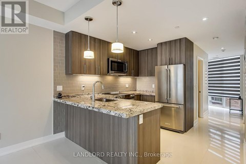 A modern kitchen with granite countertops and stainless steel appliances.