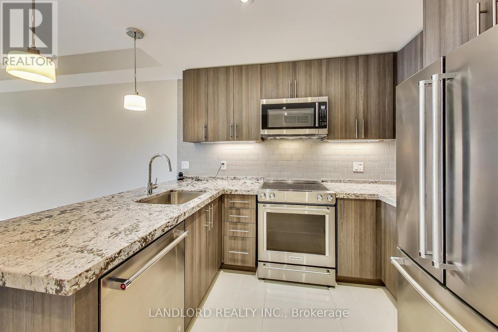 A modern kitchen with granite countertops and stainless steel appliances.