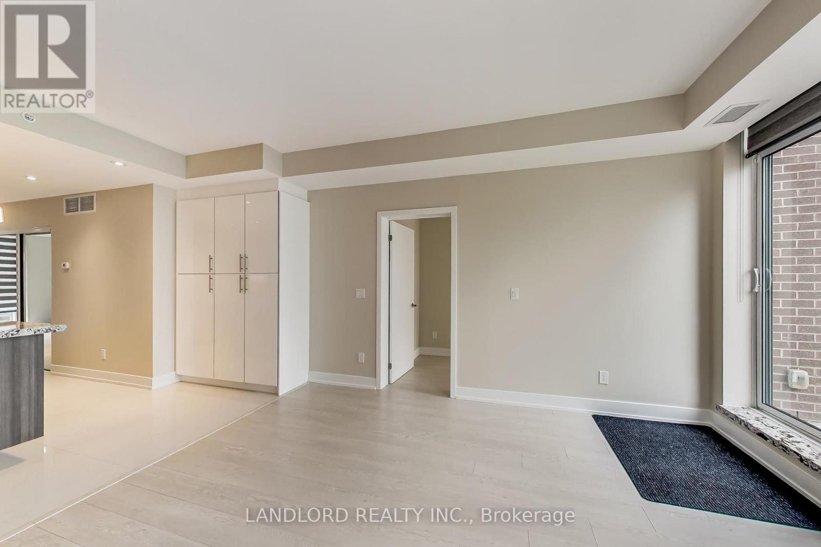 A spacious room with a large window and a view of a brick building outside.