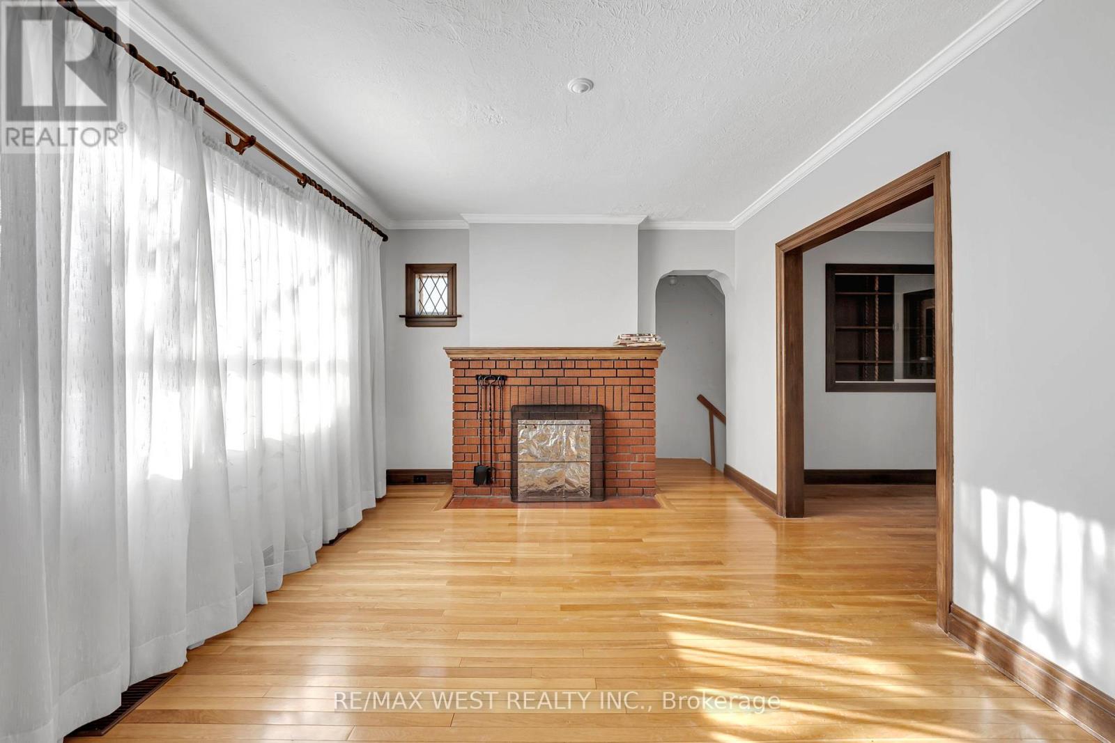 A room with a fireplace and a window with curtains.