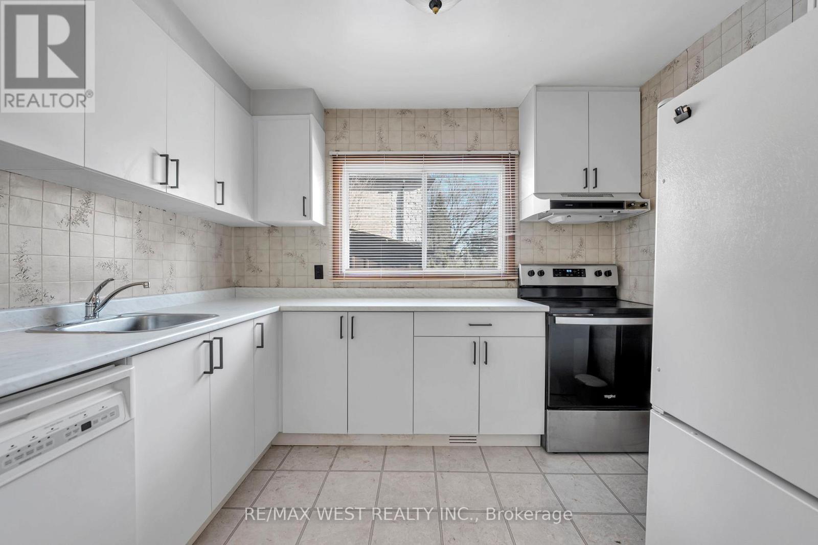 A kitchen with white cabinets and appliances.