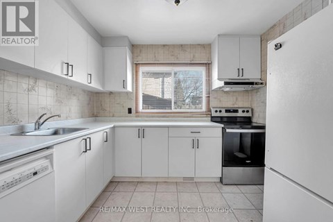 A kitchen with white cabinets and appliances.