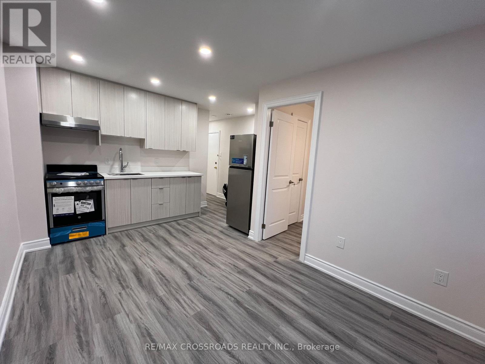 A kitchen with a grey floor and white walls.