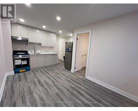 A kitchen with a grey floor and white walls.