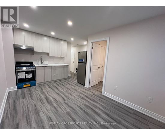 A kitchen with a grey floor and white walls.