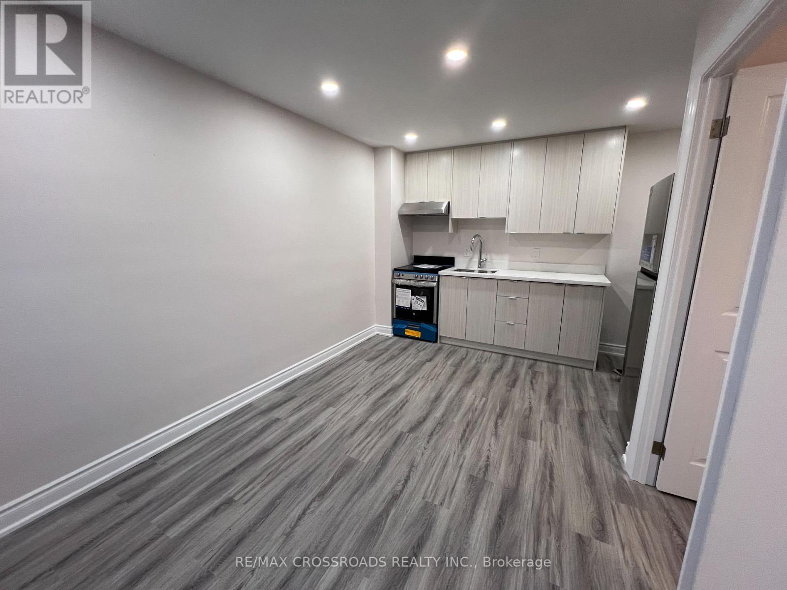 A kitchen area with a white cabinet and a grey floor.