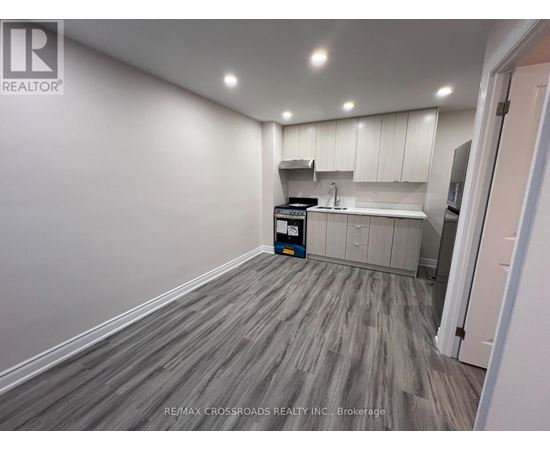 A kitchen area with a white cabinet and a grey floor.