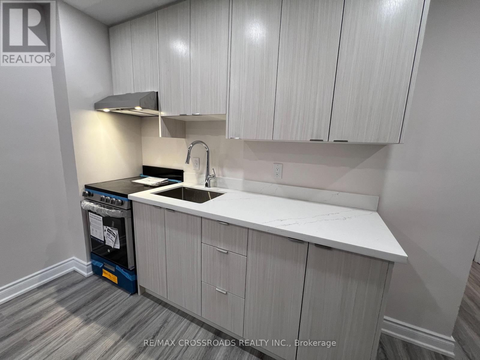 A kitchen with white cabinets and a black dishwasher.