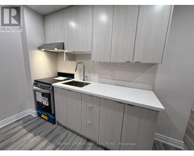 A kitchen with white cabinets and a black dishwasher.