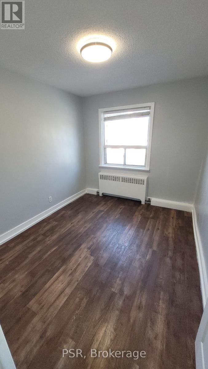 A room with wooden flooring and a window.