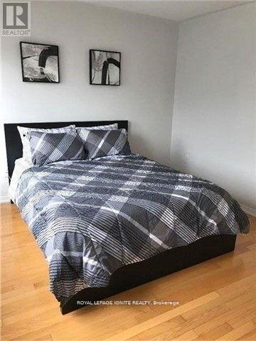 A bed with a plaid comforter and two pillows in a bedroom.