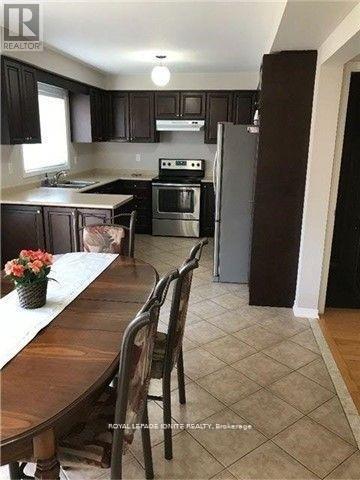 A kitchen with a table and chairs and a refrigerator.
