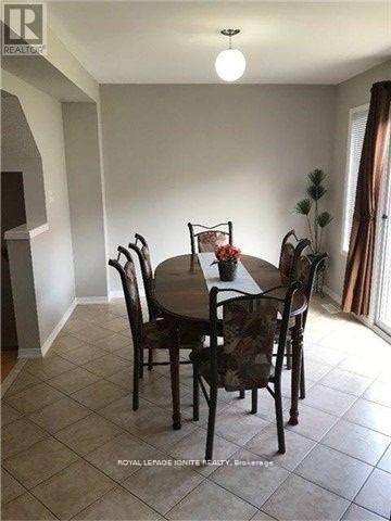 A dining room with a round table and chairs.