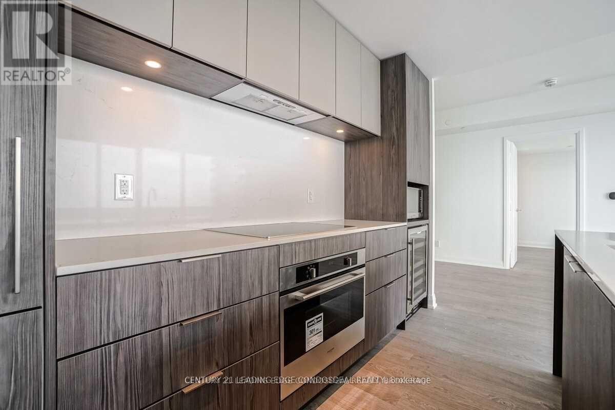 A modern kitchen with dark wood cabinets and a stainless steel oven.