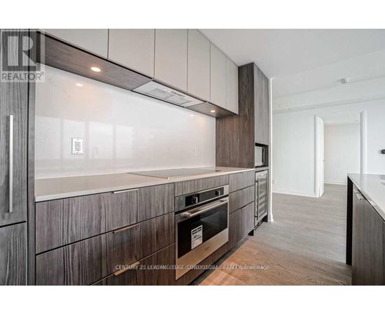 A modern kitchen with dark wood cabinets and a stainless steel oven.