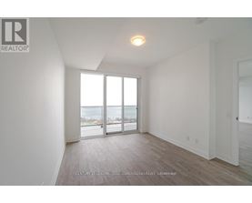 A spacious room with a view of the street through the sliding glass doors.