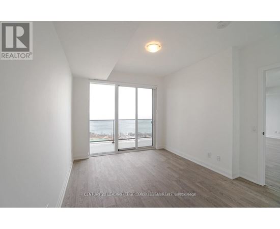 A spacious room with a view of the street through the sliding glass doors.