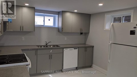 A kitchen with a stove top oven, sink, and cabinets.