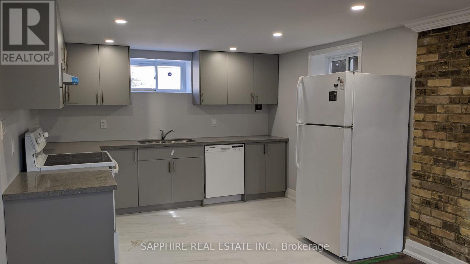 A kitchen with a refrigerator, cabinets, and a countertop.