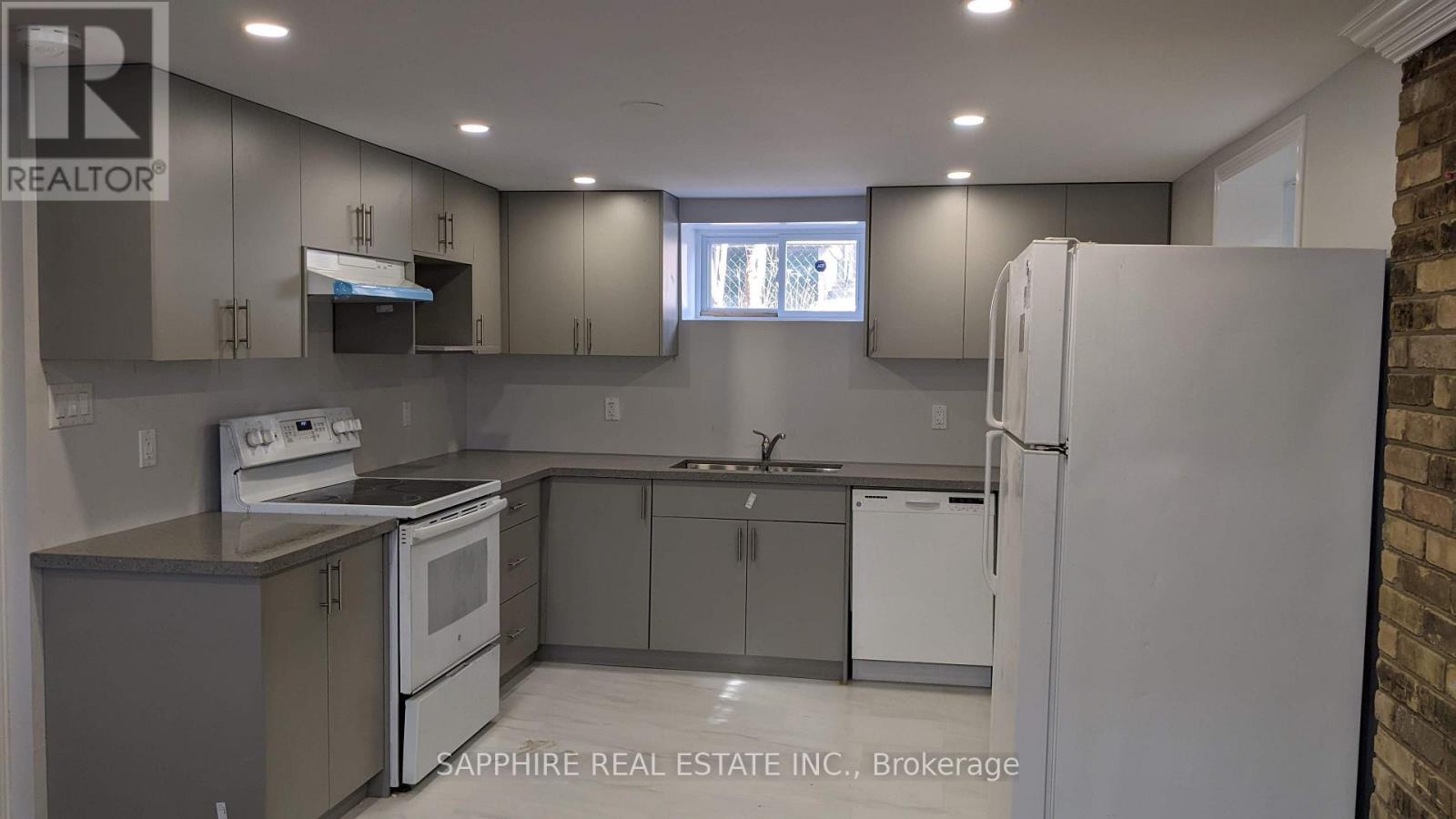 A modern kitchen with a refrigerator, stove, and cabinets.