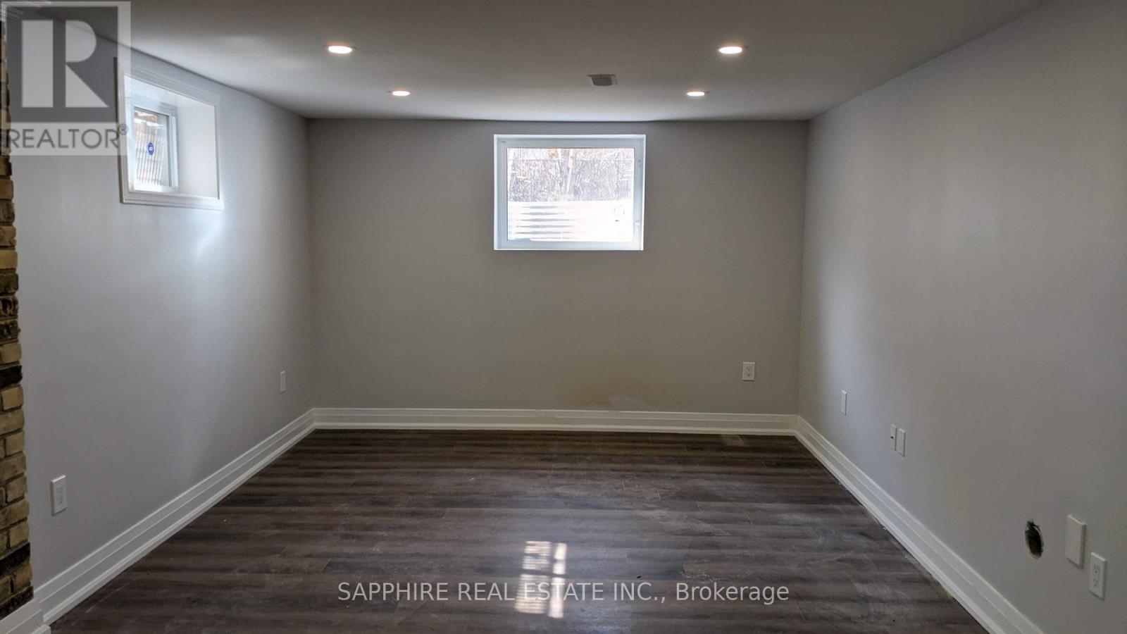 A room with a brick wall and wooden flooring.