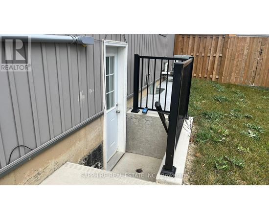 A small white door is open to a concrete step.