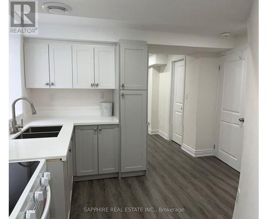 A kitchen with white cabinets and a grey countertop.