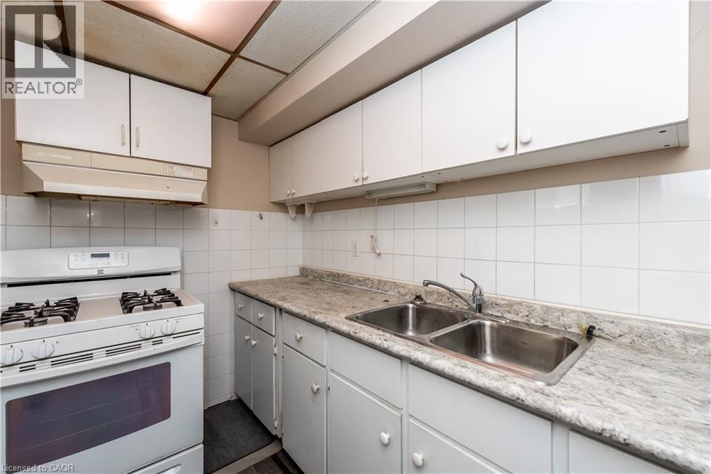 A kitchen with white cabinets and a marble countertop.