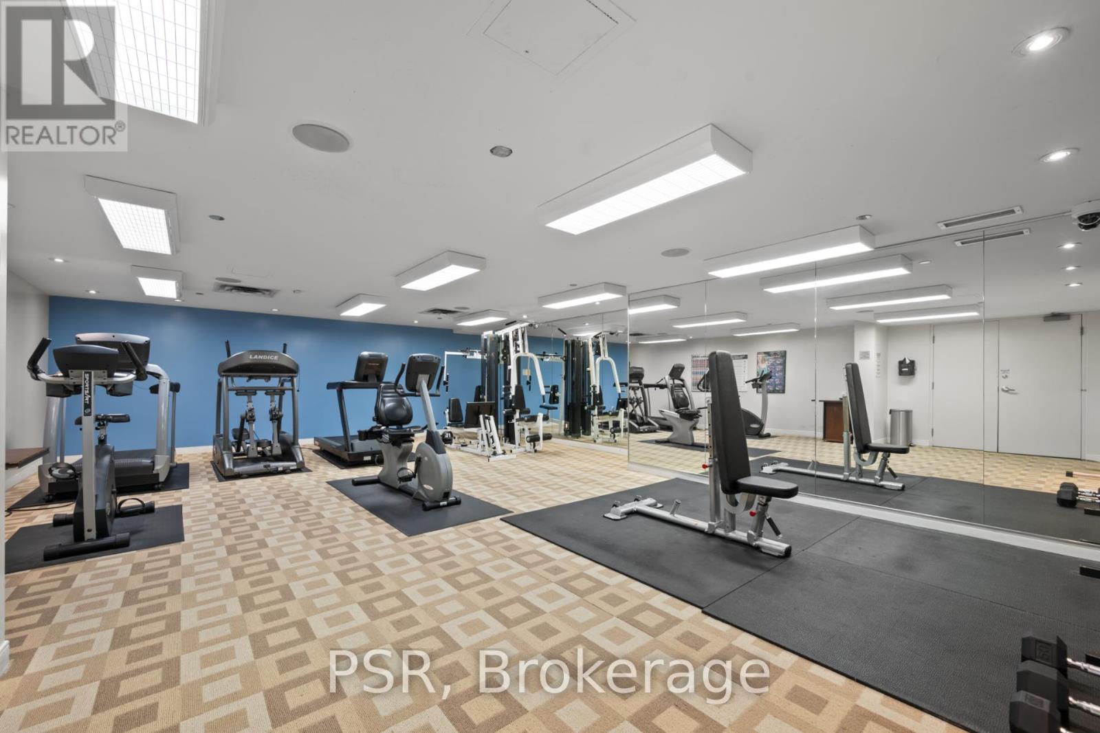 A gym with a variety of equipment including treadmills, weights, and exercise machines.