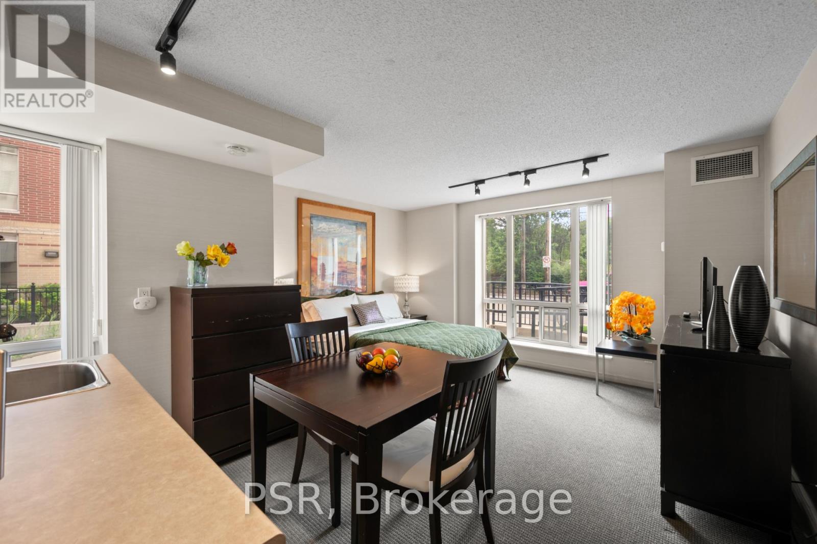 A dining room with a table set for two and a view of the backyard.