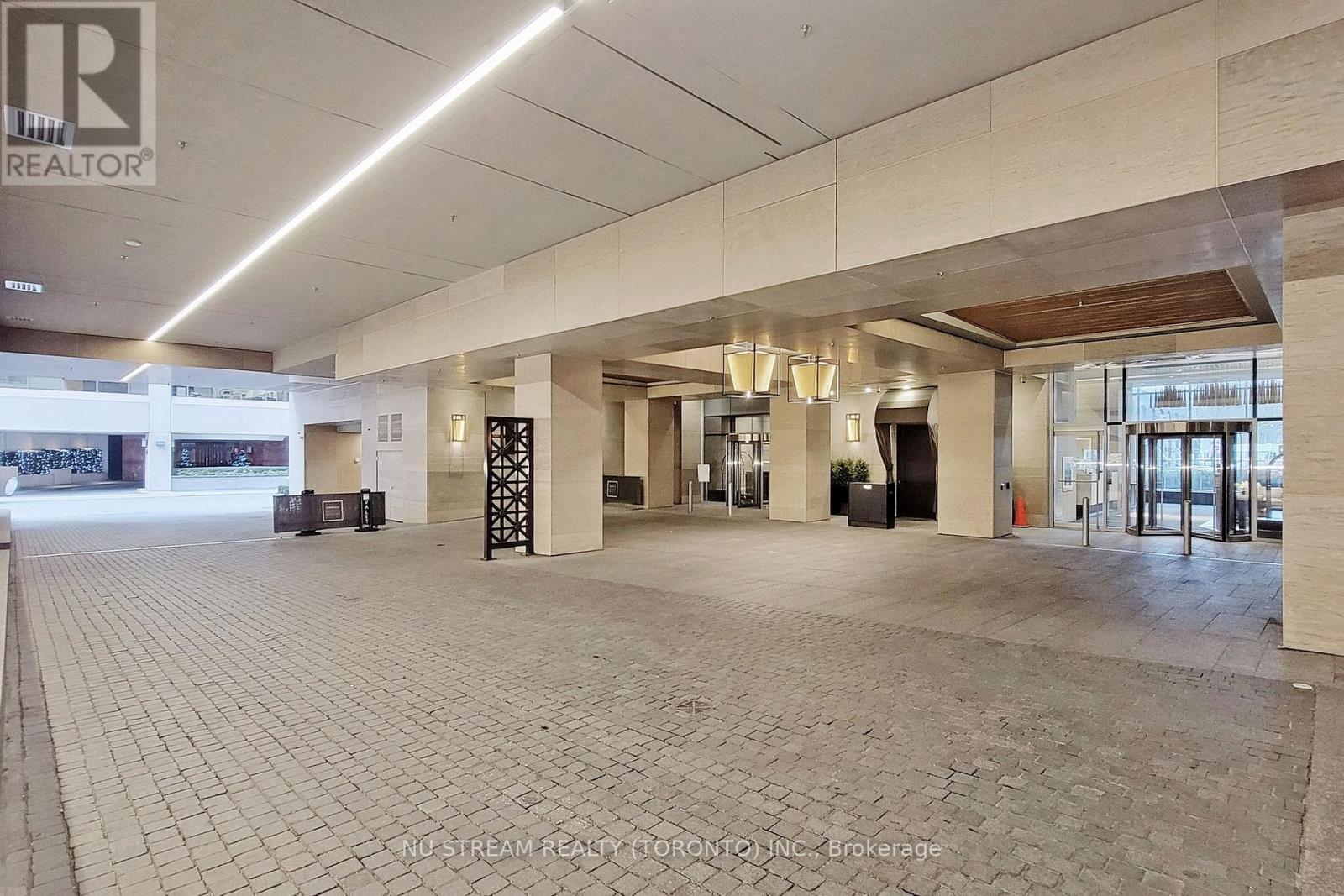A large open space with a tiled floor and a ceiling with lights.