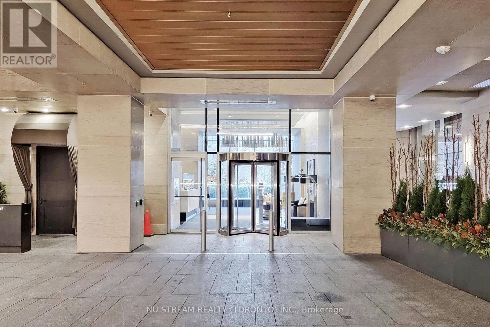The image shows the entrance to a building with a glass door and a sign that reads "REALTOR".