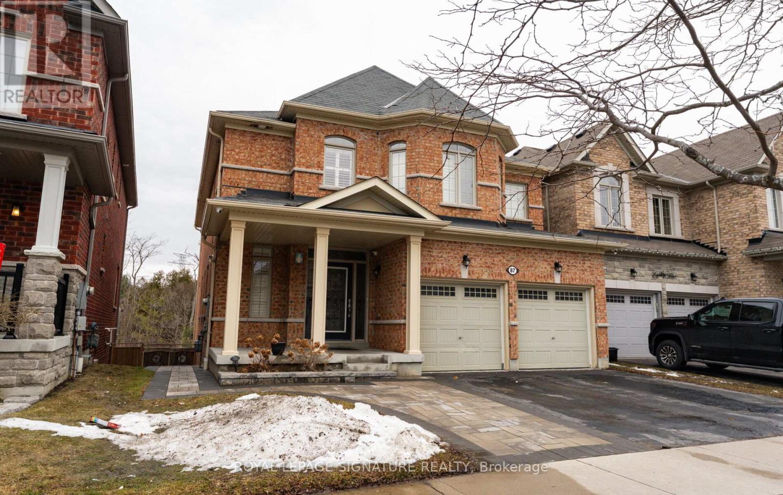 A brick house with a garage and a truck parked in front.