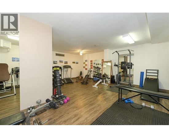 A gym with a variety of equipment including weights and cardio machines.