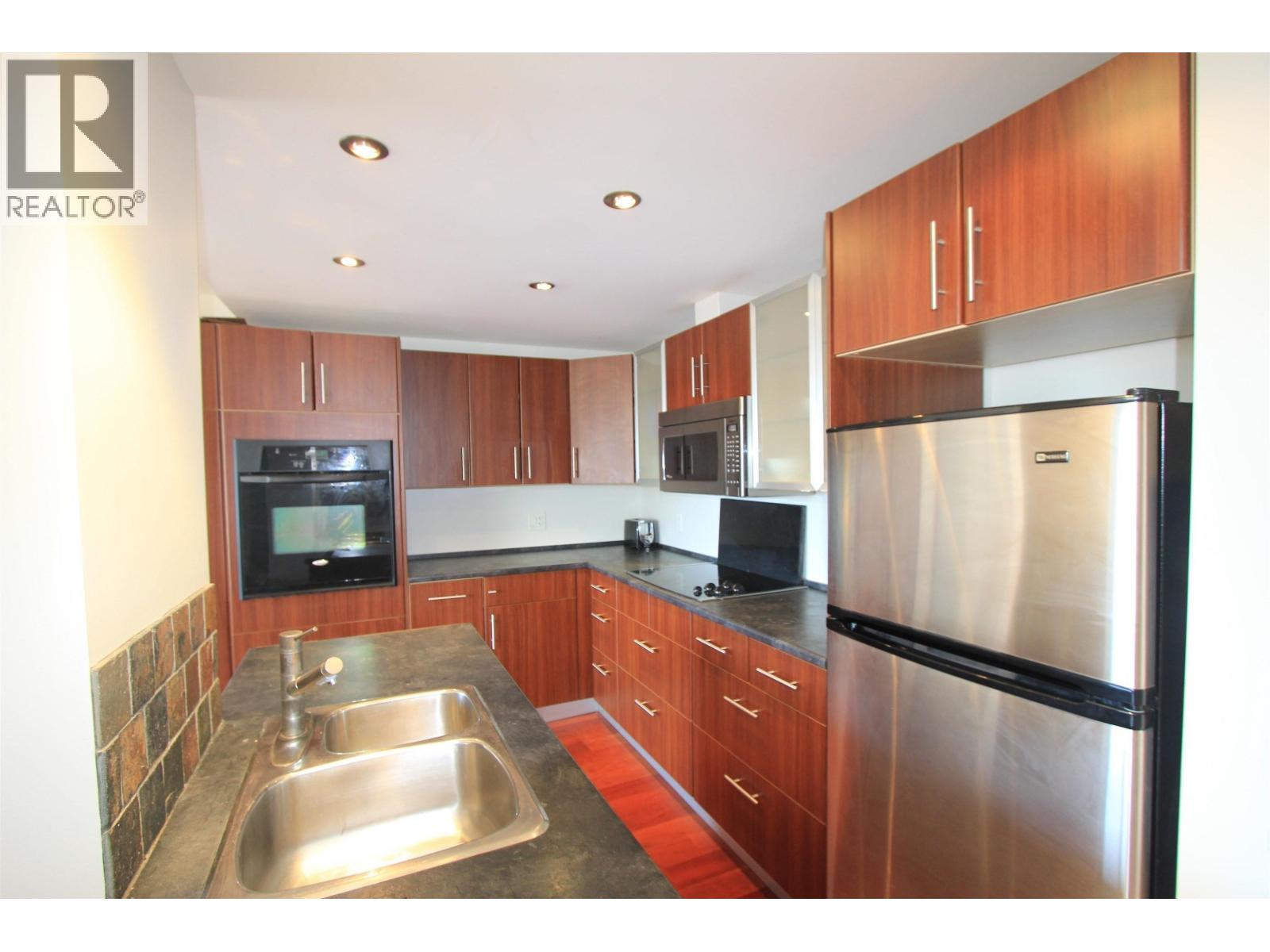 A modern kitchen with wooden cabinets and stainless steel appliances.