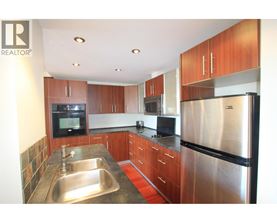 A modern kitchen with wooden cabinets and stainless steel appliances.