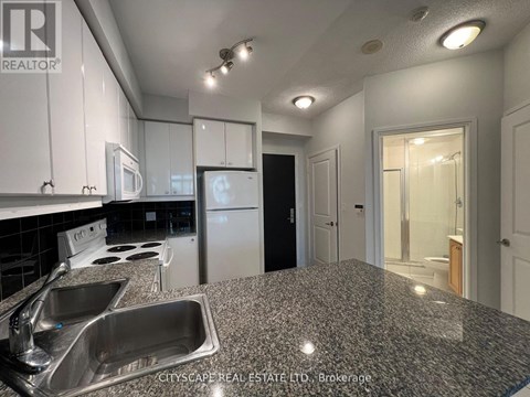 A kitchen with granite countertops and stainless steel appliances.