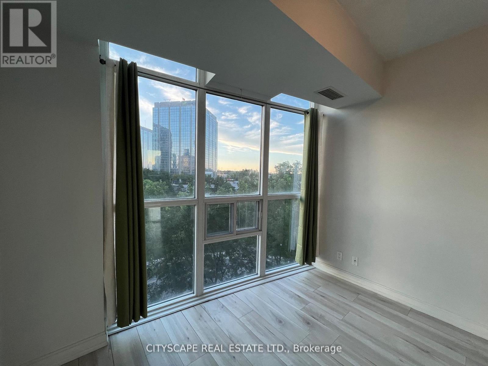 A room with a view of the city through large windows.