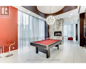A pool table in a room with a fireplace and a chandelier.