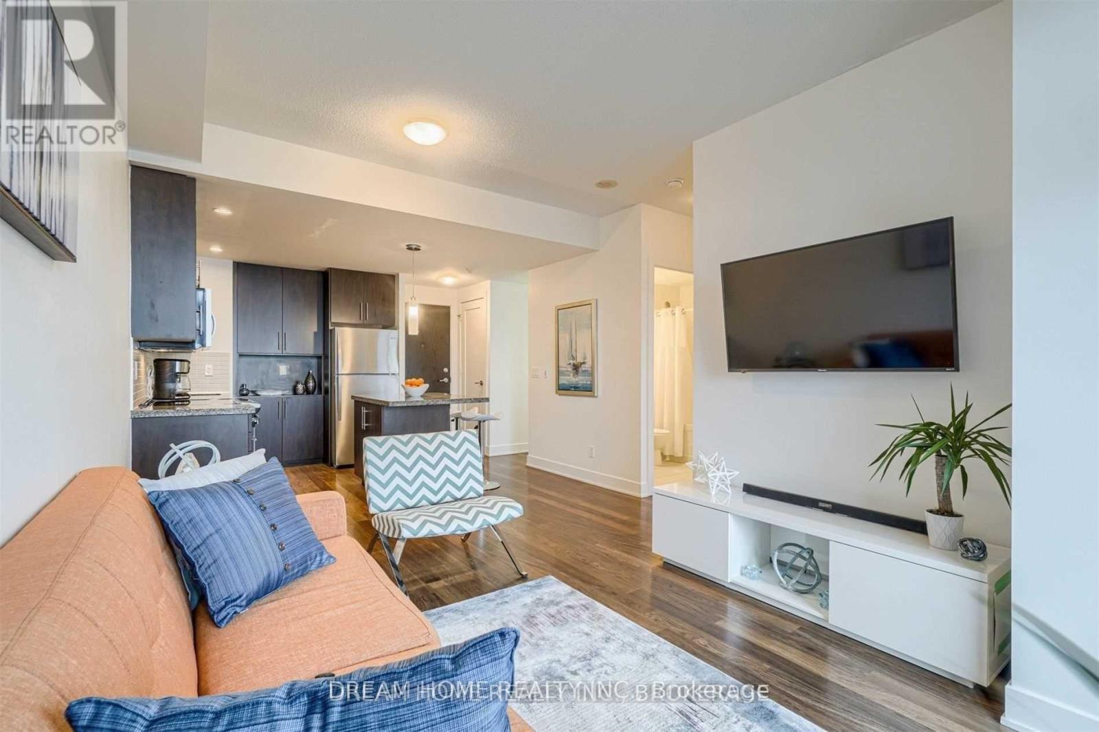 A living room with a couch, chair, and television.