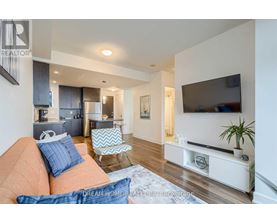 A living room with a couch, chair, and television.