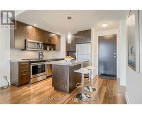 A modern kitchen with wood floors and stainless steel appliances.