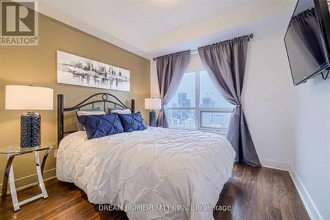 A bedroom with a large bed and a flat screen TV mounted on the wall.
